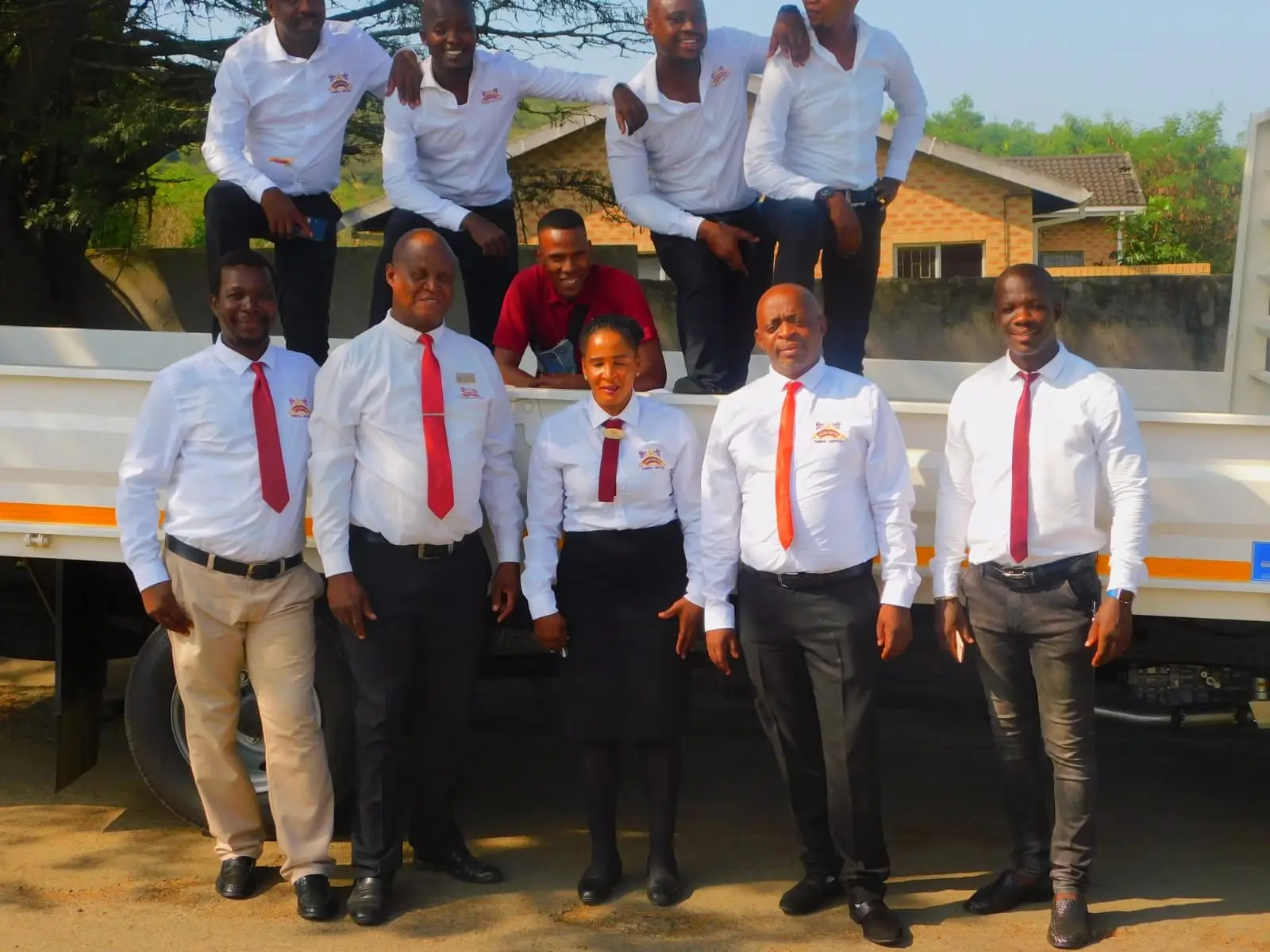 Group of Usizolwethu staff posing with a white truck