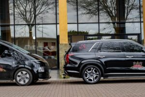 Branded black Usizolwethu funeral vehicles parked outside a branch