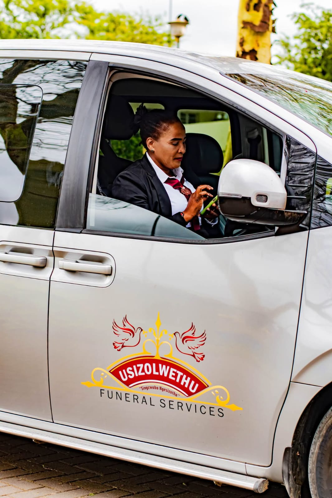 Usizolwethu staff member in a branded silver van